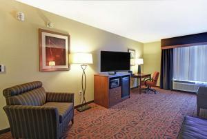 富兰克林密尔沃基/富兰克林汉普顿酒店的酒店客房配有电视、沙发和椅子。