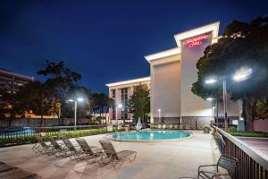 坦帕坦帕国际机场/西岸汉普顿酒店的一个带椅子的酒店庭院和夜间游泳池