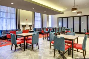 罗阿诺汉普顿酒店 - 弗吉尼亚州罗阿诺克市中心的餐厅设有桌椅和窗户。