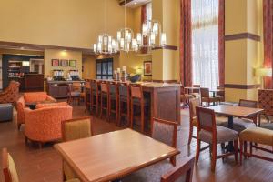 Lonoke希尔顿洛诺克汉普顿套房酒店的一间带桌椅的餐厅和一间酒吧