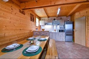 特美好Ruralna kuća za odmor RAJSKI MIR的厨房设有木墙和一张桌子,配有盘子和酒杯