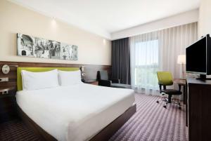 克拉科夫克拉科夫希尔顿汉普顿酒店的酒店客房配有一张床、一张书桌和一台电视。