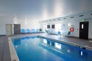 萨斯卡通南萨斯卡通汉普顿酒店的一座带蓝色椅子的大型游泳池