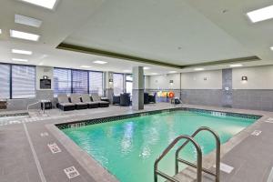萨斯卡通希尔顿萨斯卡通机场汉普顿套房酒店的酒店大堂的游泳池,设有等候室