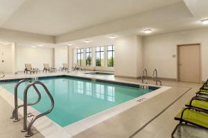 舍伍德帕克埃德蒙顿/舍伍德帕克希尔顿汉普顿酒店 的游泳池位于酒店客房内,配有桌椅