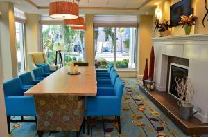代托纳海滩代托纳海滩海滨希尔顿花园酒店的一间带长桌和蓝色椅子的用餐室
