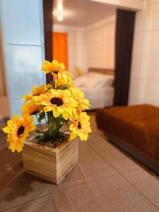 格拉玛多Residenciais Maria Flor的摆在桌子上的花瓶,上面装着黄色的花