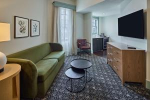 奥古斯塔奥古斯塔鹧鸪宾馆 - 希尔顿Curio Collection酒店的客厅配有绿色沙发和电视