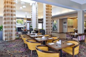 霍布斯霍布斯希尔顿花园酒店的餐厅设有木桌和黄色椅子