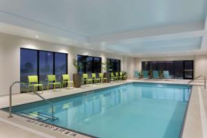 米尔顿安大略省米尔顿希尔顿欣庭套房酒店的一座配有桌椅的酒店游泳池