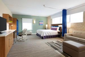 米尔顿安大略省米尔顿希尔顿欣庭套房酒店的酒店客房,配有床和沙发