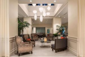迈阿密迈阿密海豚购物中心希尔顿惠庭套房酒店的大堂设有带椅子和桌子的等候室