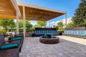 奥兰多奥兰多国际大道南希尔顿欣庭套房酒店的带顶棚的庭院配有蓝色椅子和火坑