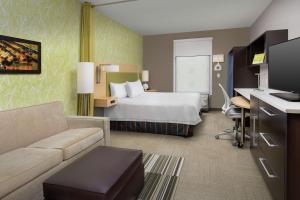 湖城湖城希尔顿欣庭套房酒店的酒店客房,配有床和沙发
