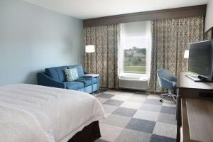 斯蒂尔沃特斯蒂尔沃特西汉普顿酒店的酒店客房配有床、沙发和电视。