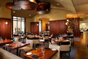 奥兰多Hilton Grand Vacations Club Las Palmeras Orlando的一间带木桌椅的用餐室和一间餐厅