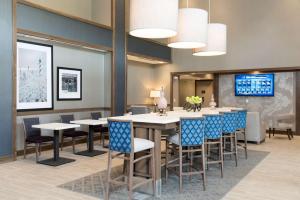 密歇根城密歇根市汉普顿酒店的一间带桌椅和电视的用餐室