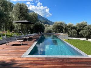 马尔切西内Olivo Luxury Apartments的甲板上配有椅子和遮阳伞的游泳池