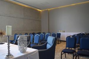 杜兰戈杜兰戈希尔顿汉普顿酒店 的一间会议室,配有蓝色的椅子、一张桌子和一张桌子以及椅子。