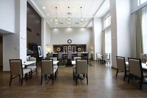 Ponca CityHampton Inn & Suites Ponca City的一间带桌椅和时钟的用餐室