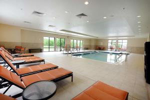 Ponca CityHampton Inn & Suites Ponca City的一个带桌椅的大房间中的游泳池