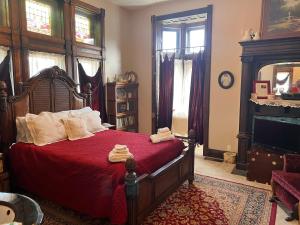 印第安纳波利斯Mansion on The Mile B&B的一间卧室配有一张红色床单和壁炉