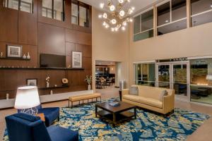 格伦代尔洛杉矶格伦代尔汉普顿套房酒店 的客厅配有蓝色家具和吊灯。