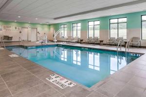 哈德森哈德森威斯康辛汉普顿套房酒店 的健身房内的游泳池,配有桌椅
