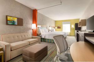 兀兰兀兰希尔顿欣庭套房酒店的酒店客房设有床和客厅。