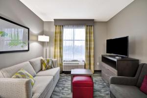 泰勒泰勒希尔顿惠庭套房酒店的带沙发和平面电视的客厅