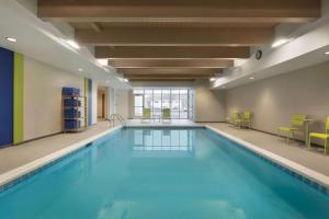 比林斯比灵斯希尔顿欣庭套房酒店的大楼内的一个蓝色海水游泳池