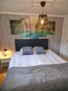 皮滕Chalet in Putten的卧室配有一张大床,墙上挂有绘画作品