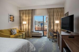 纽波特肯塔基辛辛那提新港汉普顿套房汽车旅馆的配有一张床和一台平面电视的酒店客房