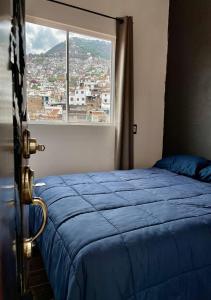 塔斯科·德·阿拉尔孔Casa céntrica con garaje的一间卧室设有蓝色的床和窗户。
