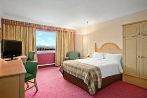 贝尔斯希尔Doubletree By Hilton Glasgow Strathclyde的配有一张床和一台平面电视的酒店客房