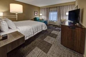 亨德森维尔Hampton Inn & Suites By Hilton Nashville Hendersonville Tn的配有一张床和一台平面电视的酒店客房