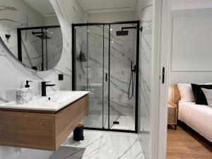 泰尔莫利Cindy Rooms的一间带玻璃淋浴和水槽的浴室