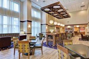 阿什兰俄亥俄亚什兰汉普顿酒店 的餐厅设有桌椅和窗户。