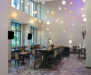 明尼阿波利斯明尼苏达州明尼阿波利斯大学区旅馆及套房汉普顿酒店的用餐室设有桌椅和窗户。