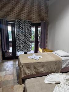 巴雷里尼亚斯Pousada Solar dos Lençóis的酒店客房设有两张床和窗户。