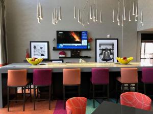 摩尔Hampton Inn & Suites-Moore的厨房配有带椅子的酒吧和一台电视
