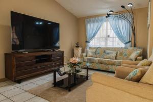 SavanetaBlue Sky Residence Aruba的客厅配有平面电视和沙发。