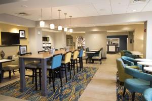 迪凯特Hampton Inn Decatur, Mt. Zion, IL的一间带桌椅的用餐室