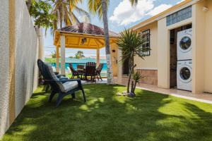SavanetaBlue Sky Residence Aruba的一个带长凳和房子的院子