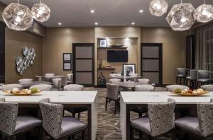 布里奇沃特新泽西州布里奇沃特汉普顿酒店的用餐室配有桌椅和吊灯。