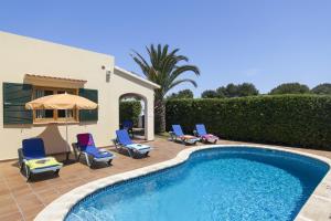 卡拉布兰卡Villa Menorca Cleo by Mauter Villas的房屋旁的游泳池配有椅子和遮阳伞