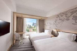 新加坡Hilton Garden Inn Singapore Serangoon的酒店客房设有两张床和窗户。