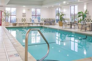 切尔西波士顿洛根机场希尔顿逸林酒店的酒店大堂设有桌椅的游泳池