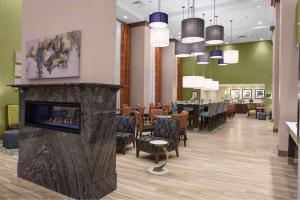 北锡拉丘兹雪城华美达酒店的带壁炉的等候室和餐厅