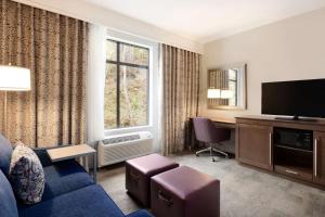 伦顿汉普顿酒店及套房西雅图/兰顿，华的客厅配有蓝色的沙发和电视